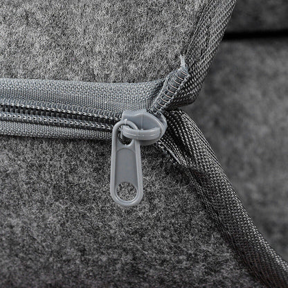 Close-up of a gray bag with a zipper on a textured surface