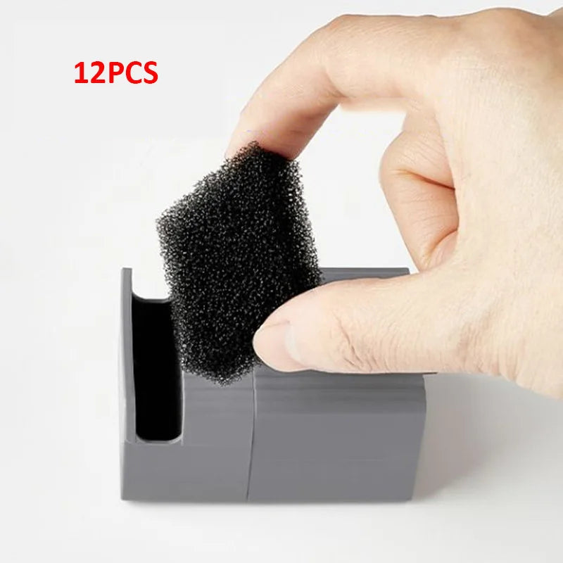 Hand holding a black foam brush with a container of additional brushes on a light gray background.
