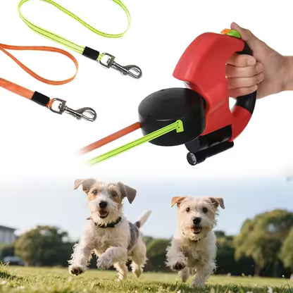 Retractable dog leash with a hand holding it, and two dogs running in a park.