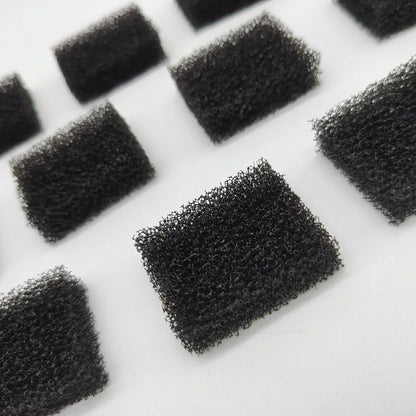 Black foam filters arranged on a white background
