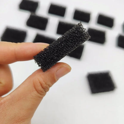 Black honeycomb filter held by a hand with a blurred background of similar filters.