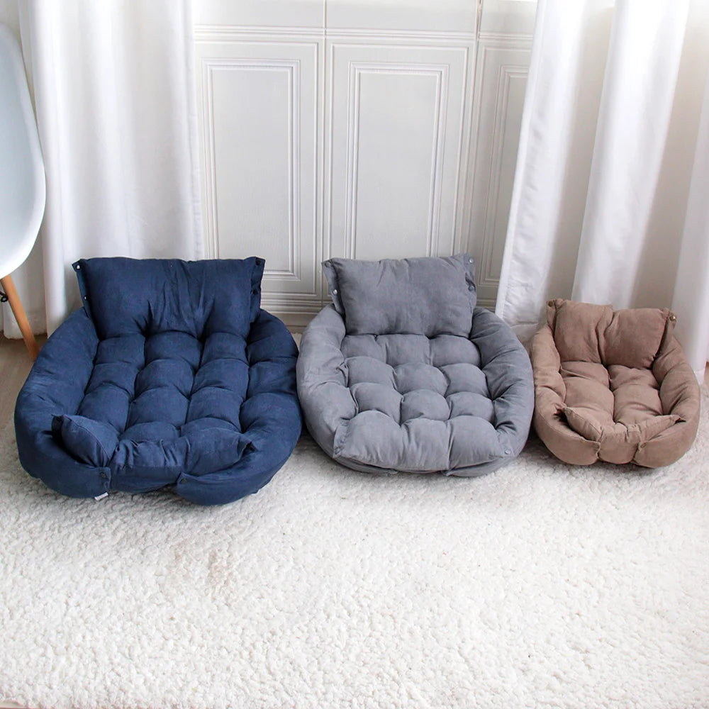 Three cushioned pet beds in blue, grey, and brown on a carpeted floor.