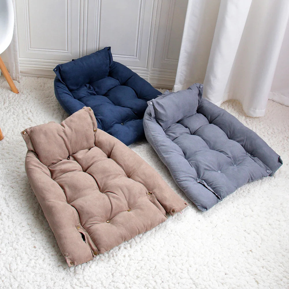 Three cushioned pet beds in blue, beige, and grey on a white carpet.